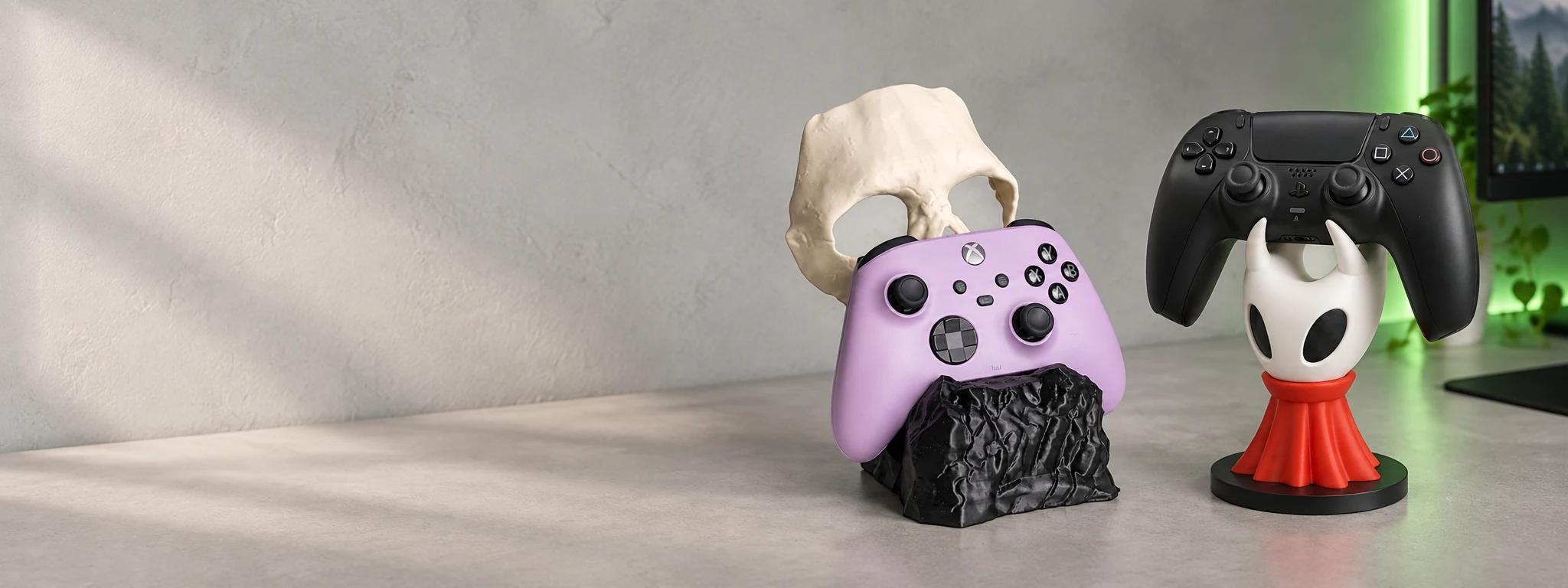 Ghost ve Hollow Knight gamepad stantları, açık renkli bir oyun masasında.